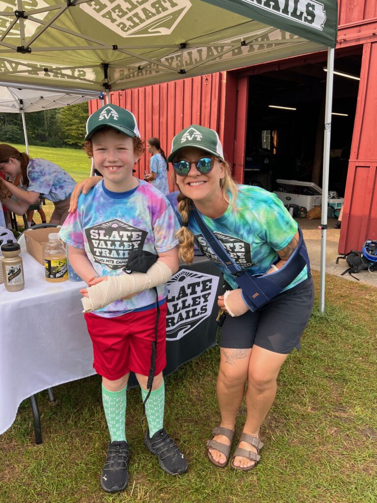 Photos of Slate Valley Trail's new executive director Courtney Behnken at youth mountain bike camp with a student in tie dye, biking in a downhill race, and spray painting a cardboard mushroom